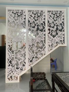 an intricately designed wall divider in a room with white walls and flooring