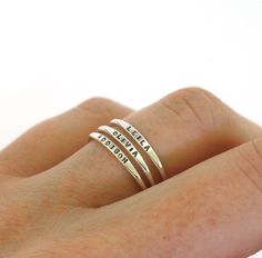 a woman's hand with three rings on it