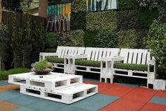 two white benches sitting next to each other on top of a patch of blue and red tile