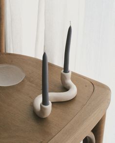 two candles sitting on top of a wooden table