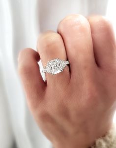 a woman's hand with a diamond ring on it