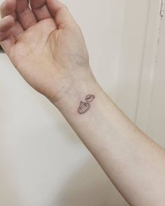 a small saturn tattoo on the wrist