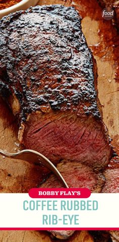 a piece of steak on a wooden cutting board with a fork in it and the words coffee ribbed rib - eye