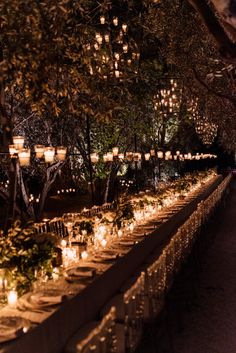 a long table covered in lots of lit candles