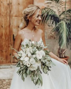 a woman in a wedding dress holding a bouquet