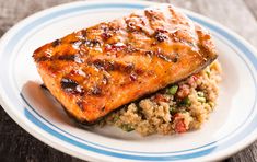 a white plate topped with salmon and rice