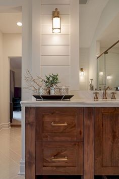 a bathroom with two sinks and wooden cabinets