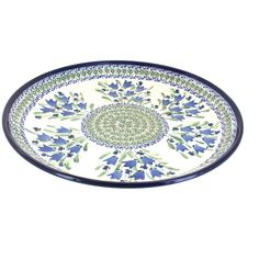 a blue and white platter with flowers on the bottom, sitting in front of a white background