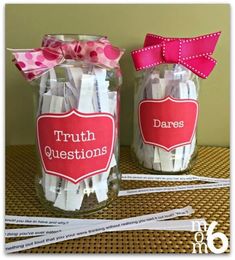 two jars with toothbrushes in them on a table