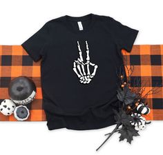 "Halloween Shirt for Women, Skeleton Hands Halloween Shirt, Skeleton Peace Sign Halloween Shirt, Kids Halloween Shirt, Pumpkin Halloween T-shirt ---How To Order --- 1-) Please, check and review all photos 2-) Choose your t-shirt size and color 3-) Write your design color in personalization box 4-) Click add to cart. You can go back to add more product 5-)Click \"Proceed to check out\" 6-)When you check out, you can add a note to seller for any request SIZE AND COLORS: For sizing details and colo Skeleton Peace Sign, Peace Sign Shirt, Peace Sign Shirts, Women Skeleton, Halloween Shirts Kids, Skeleton Shirt, Skeleton Hand, Skeleton Hands, Women Halloween