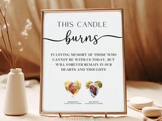 this candle burns memorial sign is next to a vase with flowers in it and two candles on the table