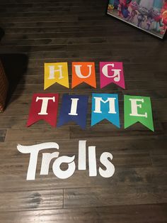 the words hug time and tails are painted on wood flooring with colorful pennants