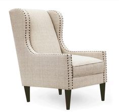 an upholstered chair with studding on the arms and back, in beige linen