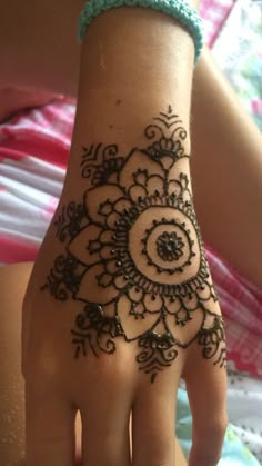 a woman's hand with a henna tattoo on it