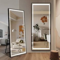 two large mirrors sitting next to each other on top of a wooden floor in front of a living room