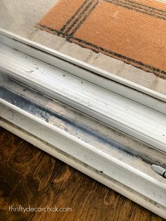 an old window seal on the outside of a house with wood flooring behind it