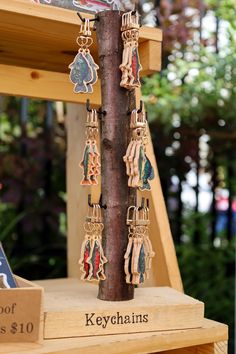 the keychains are hanging from the tree in front of the store's sign