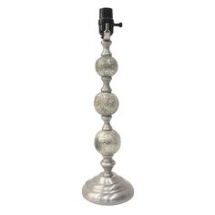 a silver metal candle holder with three balls on it's base and a black top