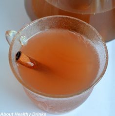 a glass cup filled with liquid and a cinnamon stick sticking out of it's top