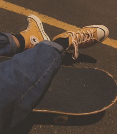 a person sitting on top of a skateboard in the middle of a street with their feet up