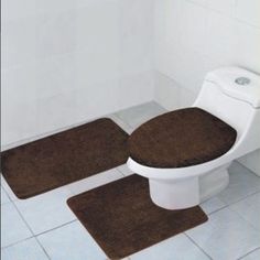 two red rugs sit next to a toilet in a bathroom