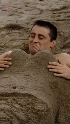 a man is buried in the sand with his hands on his face