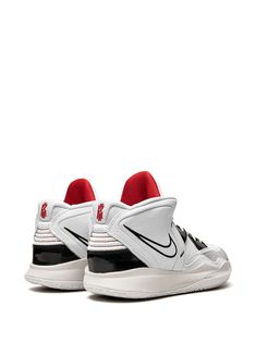 a pair of white and black sneakers with red accents on the upper part of the shoe