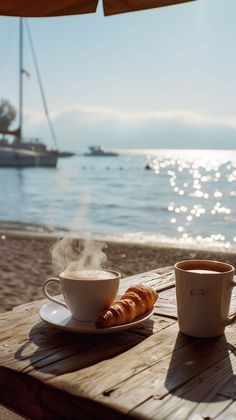 coffee and croissants on a wooden table at the beach