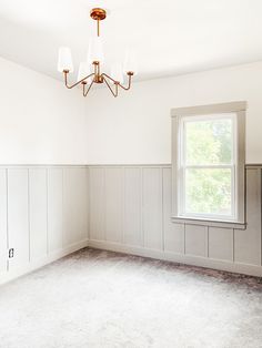 an empty room with white walls and wood paneling