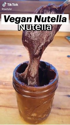 a jar filled with nutella sitting on top of a wooden table