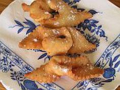 some fried food on a blue and white plate sitting on top of a wooden table