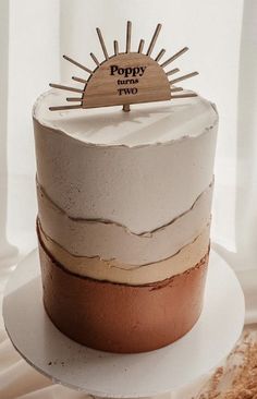 there is a cake with white frosting and brown icing on the top that says poppy two