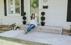 a woman sitting on the front steps of a house