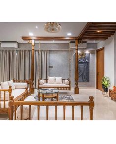 a living room filled with furniture and a chandelier hanging from the ceiling above it