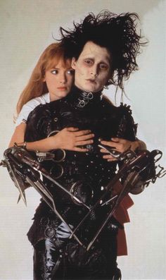 two people dressed in black and one is holding her arms around the other's shoulders