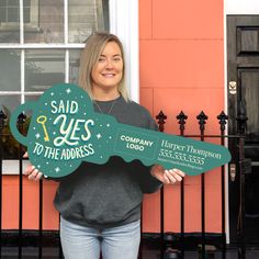 a woman holding up a sign that says said yes to the address