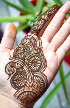 the hand is decorated with henna on it's palm and has an intricate design