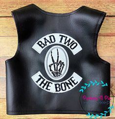 a black leather vest with the words bad two and an image of a hand on it