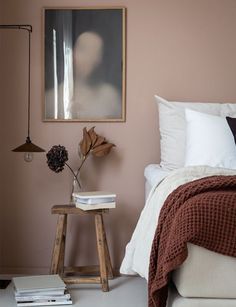 a bed room with a neatly made bed and two pictures on the wall above it