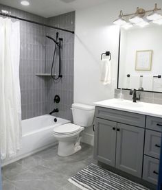 a white toilet sitting next to a bath tub in a bathroom