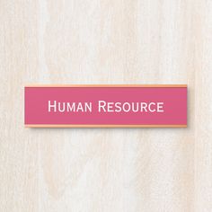 a pink sign that says human resources on the side of a wooden wall with wood grained background