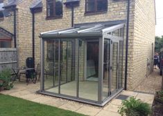 a glass enclosed patio area in front of a house