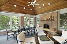 a living room filled with furniture and a fire place under a ceiling mounted flat screen tv