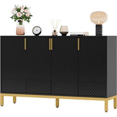 a black and gold sideboard with flowers on top, a clock and other items