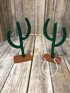 pair of green metal cactus bookends on wooden background