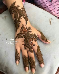 a woman's hand is decorated with hennap and floral designs on it