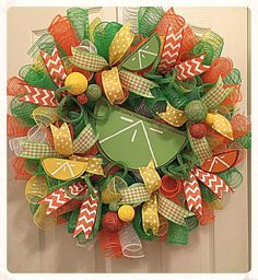 a green wreath with orange and yellow decorations