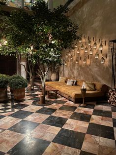 a living room filled with furniture and potted plants on top of a checkered floor