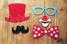 three different types of props are on a table with wood planks and one has a top hat, bow tie, mustache, and eyeglasses