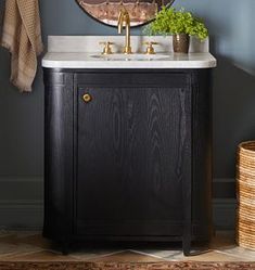 a bathroom sink with a mirror above it next to a towel rack and rug on the floor